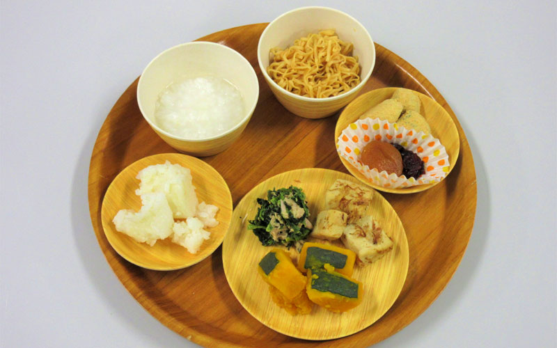 A meal by Kazuko Iida with various dishes on a wooden tray