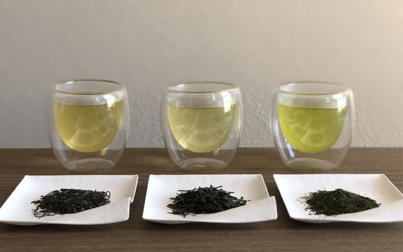Green tea in cups and tea leaves on plates