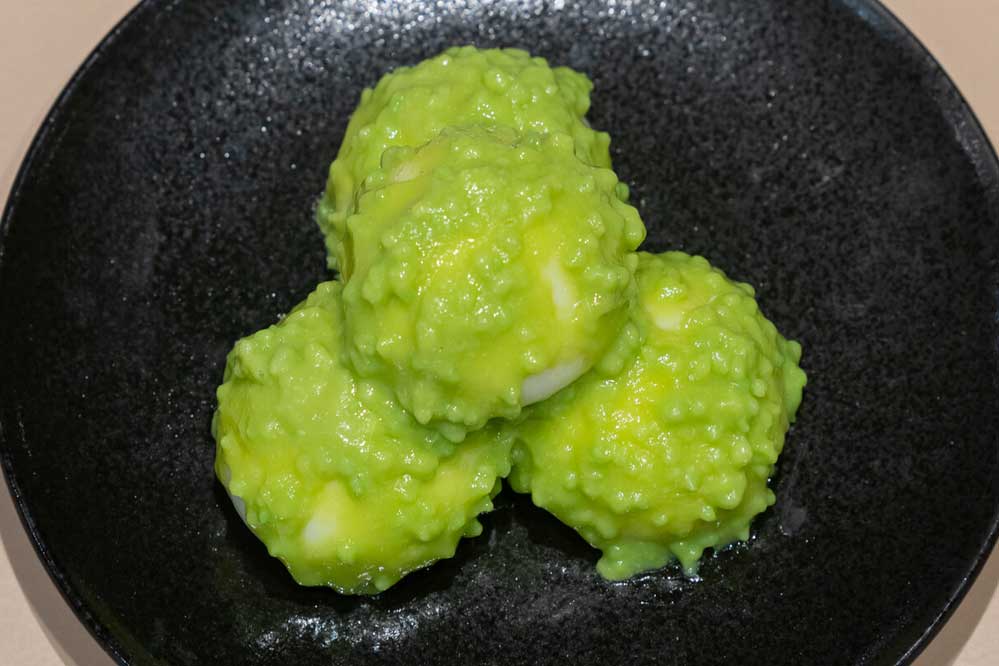 Food replica of zunda-mochi on a black plate