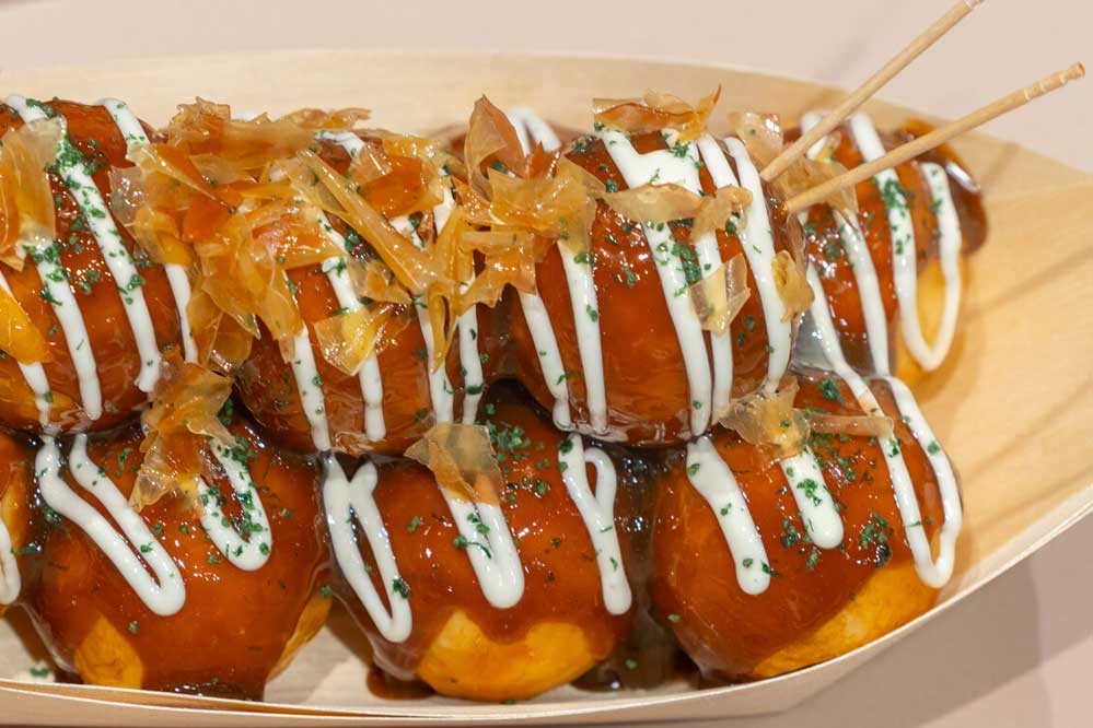 Food replica of takoyaki garnished with sauce, mayonnaise, bonito flakes and ao-nori