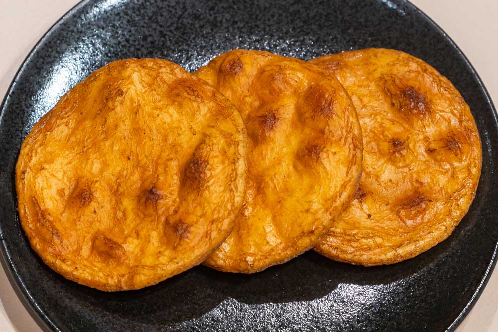 A food replica of Sōka senbei (rice crackers) on a black plate