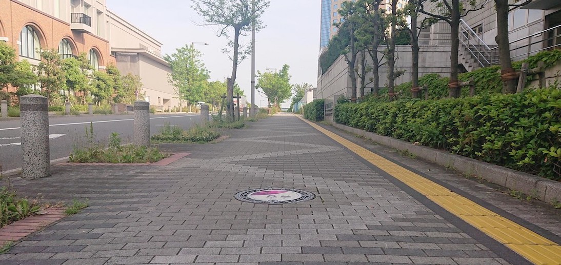 image of a street in Japan with an Olympic-themed manhole cover on the ground