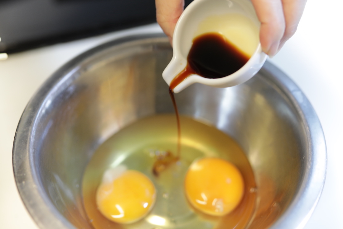 mixing soy sauce, dashi, and sugar into eggs