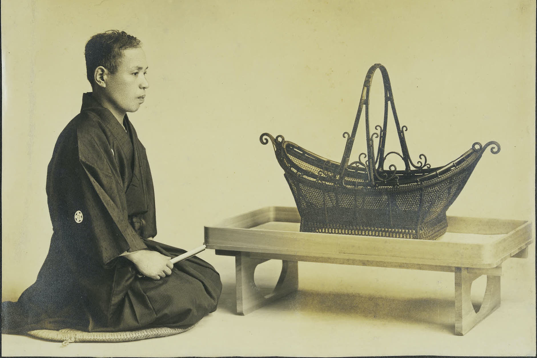 Chikuunsai I sitting next to handwoven basket