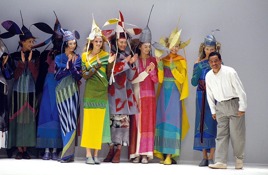 Issey Miyake standing with several fashion models
