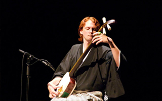 Mike Penny in a kimono, performing the tsugaru shamisen.