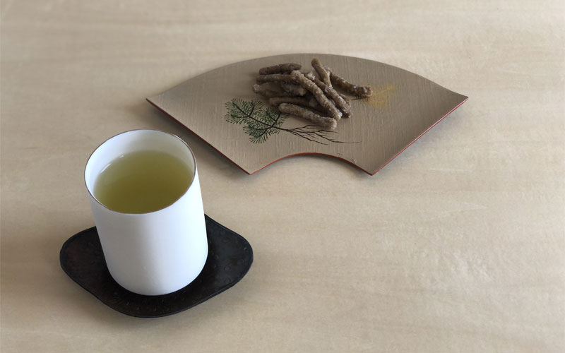 A cup of green tea with Japanese snacks
