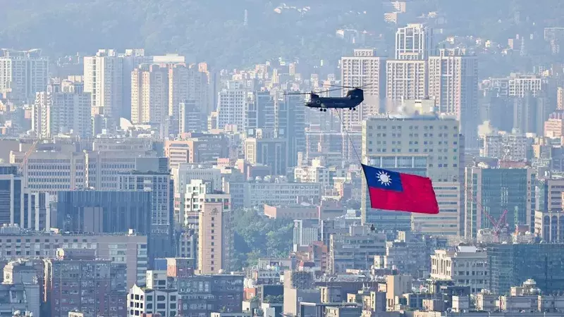 A CH-47 carries a Taiwan flag over the city of Taipei, Taiwan