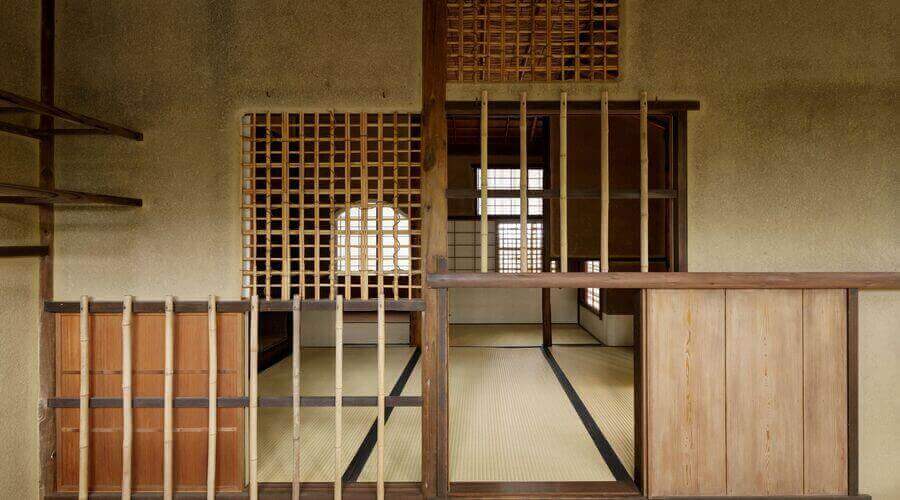 Traditional Japanese interior with wooden screens, partitions, and tatami mats, showcasing natural light.