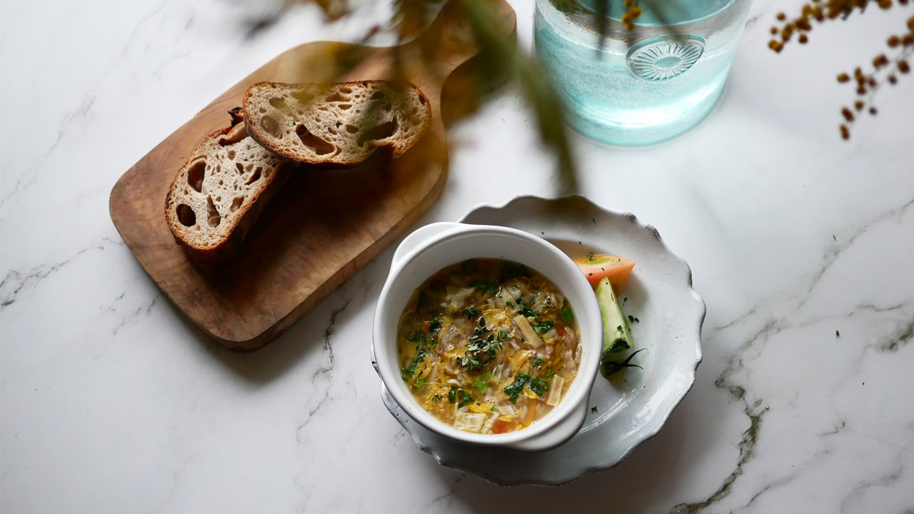 Realistic faux food display with a bowl of soup and bread, highlighting sampuru craftsmanship.